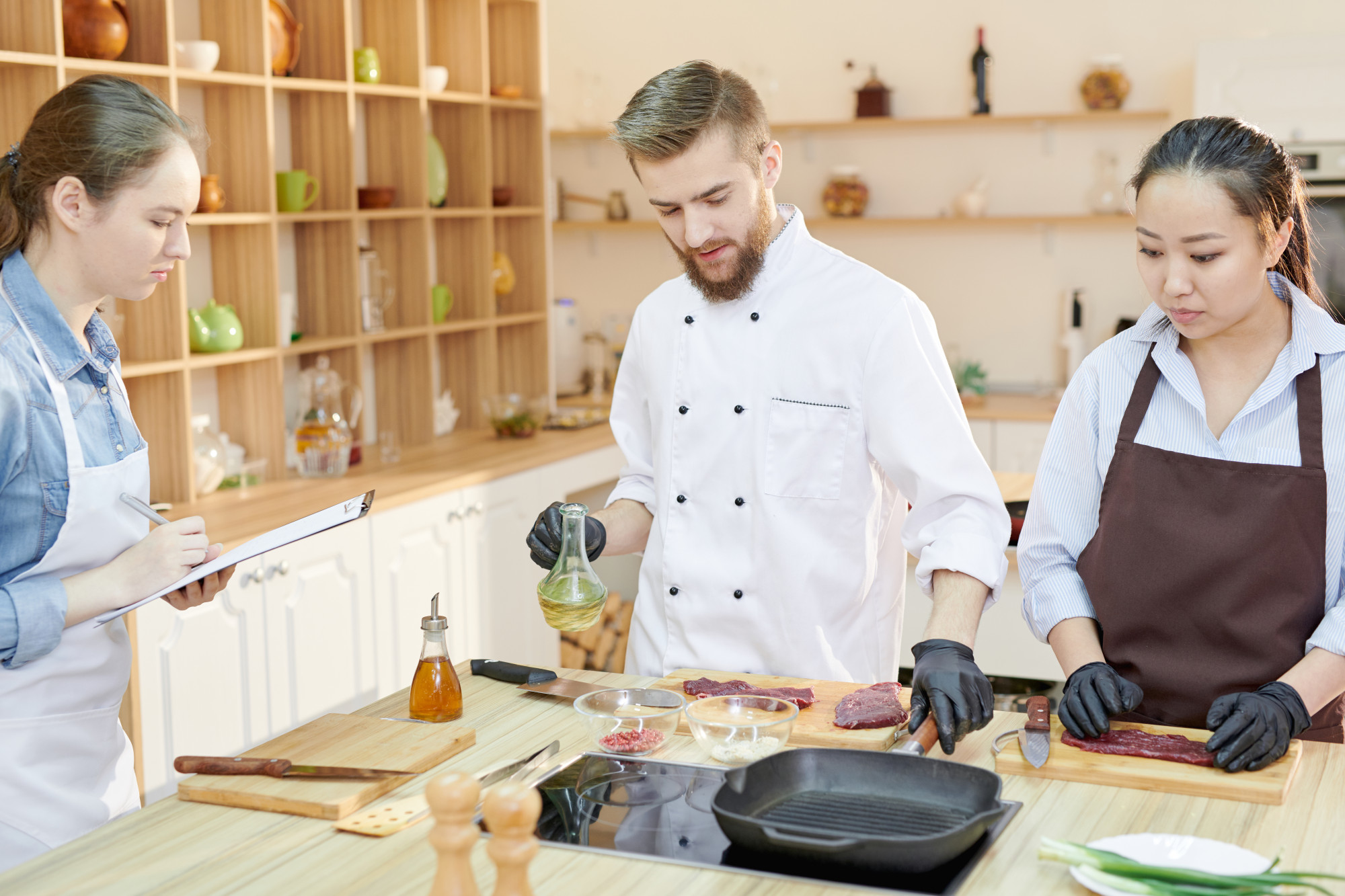 Participants learning with a chef at a stove